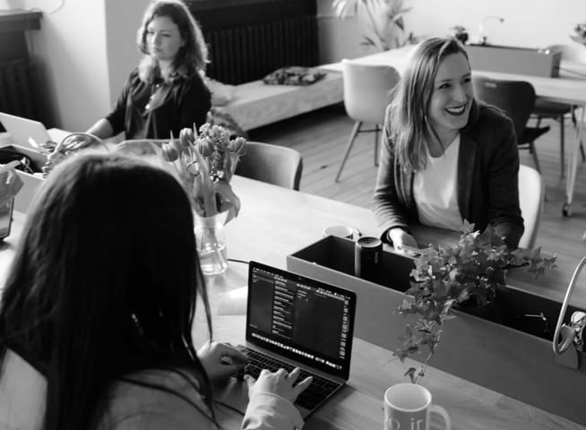 three women working on laptops